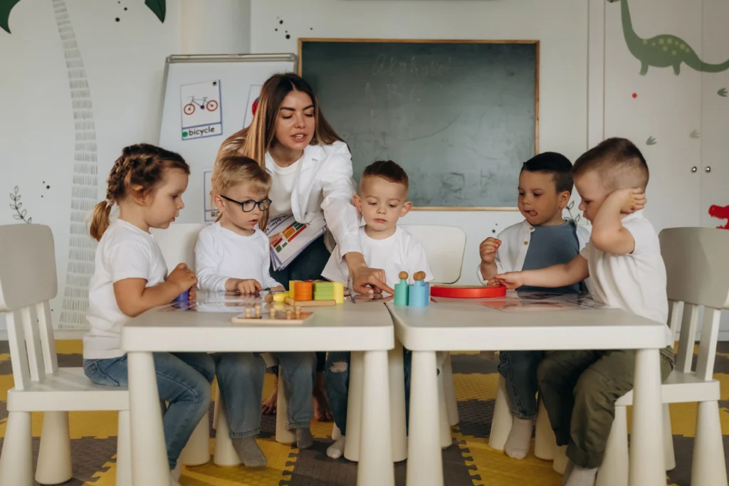 A childcare specialist in daycare fostering group participation in daycare between kids