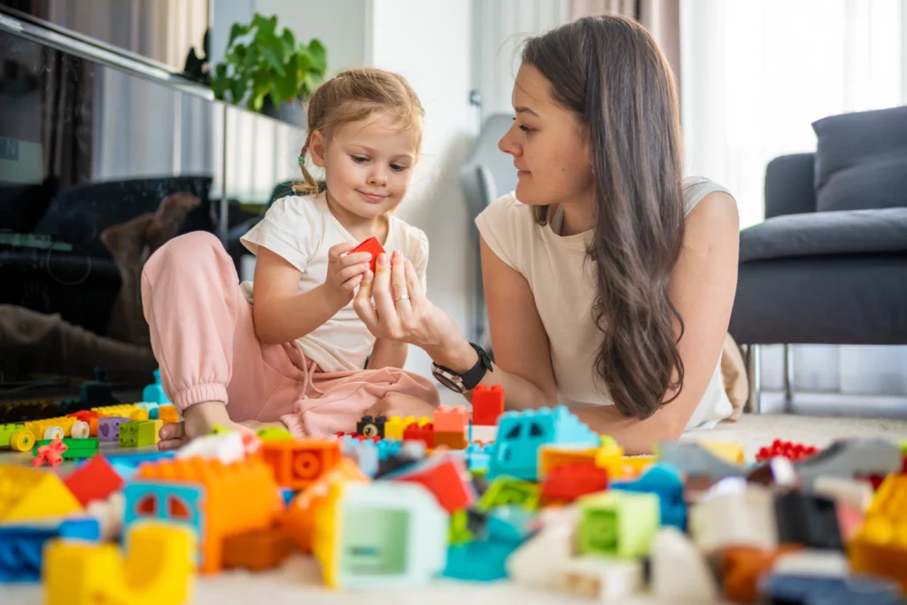 A woman looking at a child while playing with her.