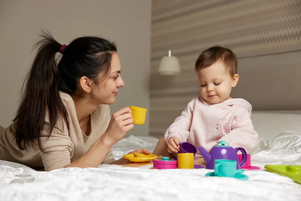 A nanny playing with the child.
