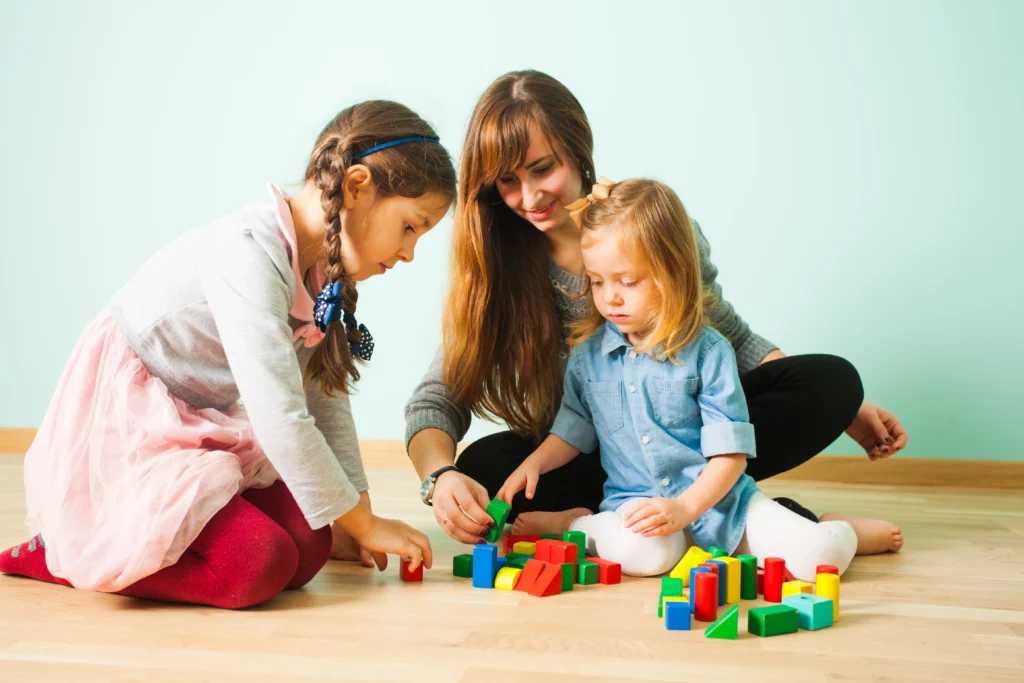 A Nanny playing with children in a private household