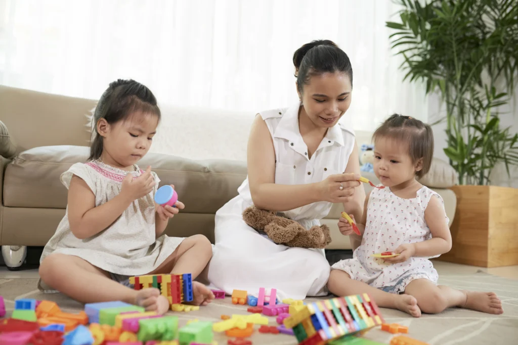 A Nanny playing with children to foster their development.