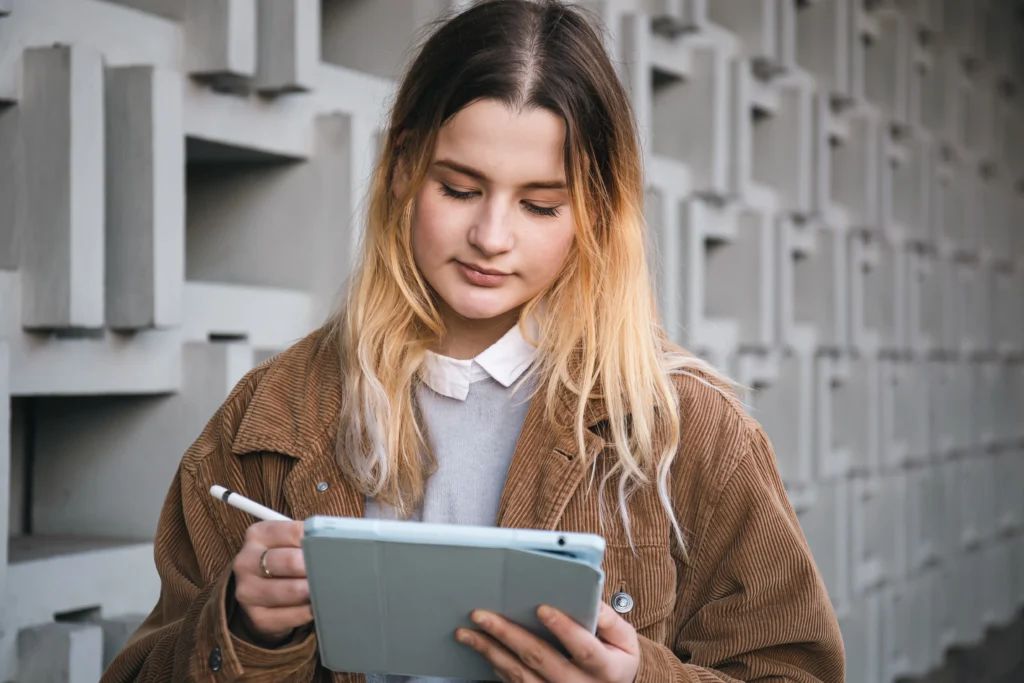 A nanny professional using tablet to search for the Right Nanny Certification Program